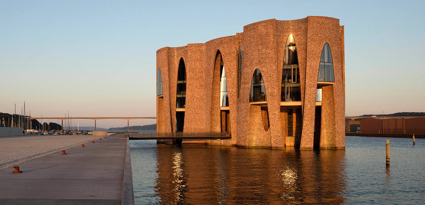 Fjordenhus with sun on it at sunset