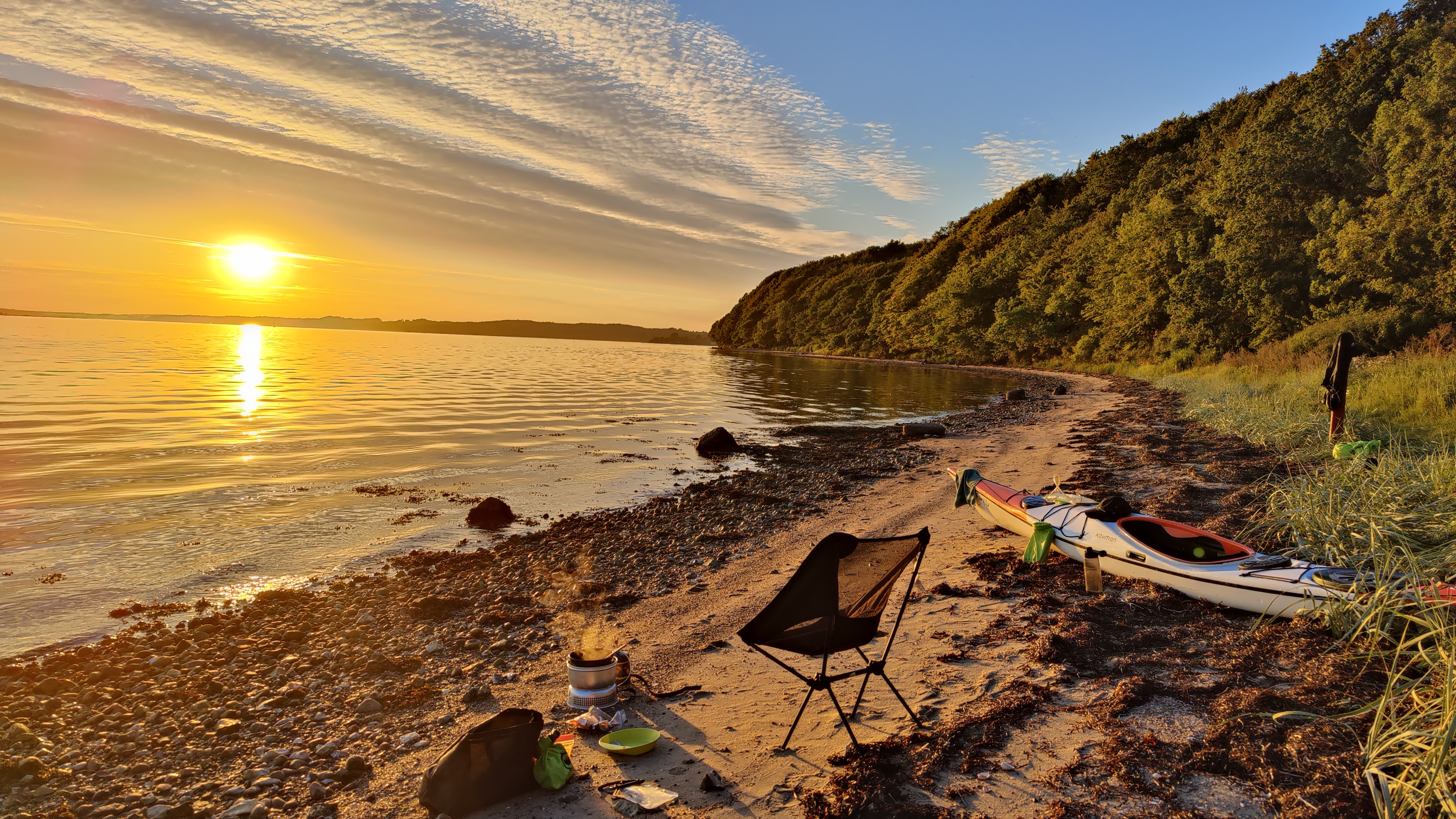 Kajak ved stranden med solopgang