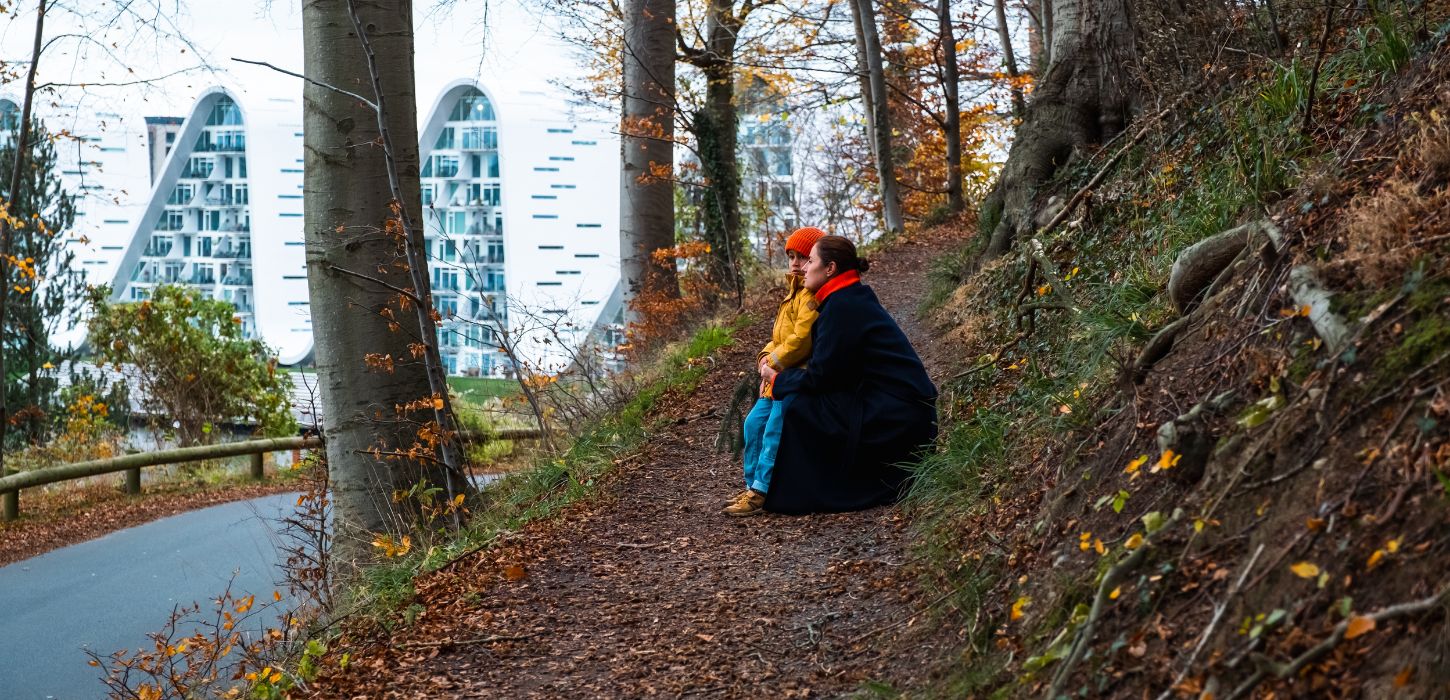 Mother and child on a walk in Nørreskoven in Vejle in autumn with a view of Bølgen and the waterfront