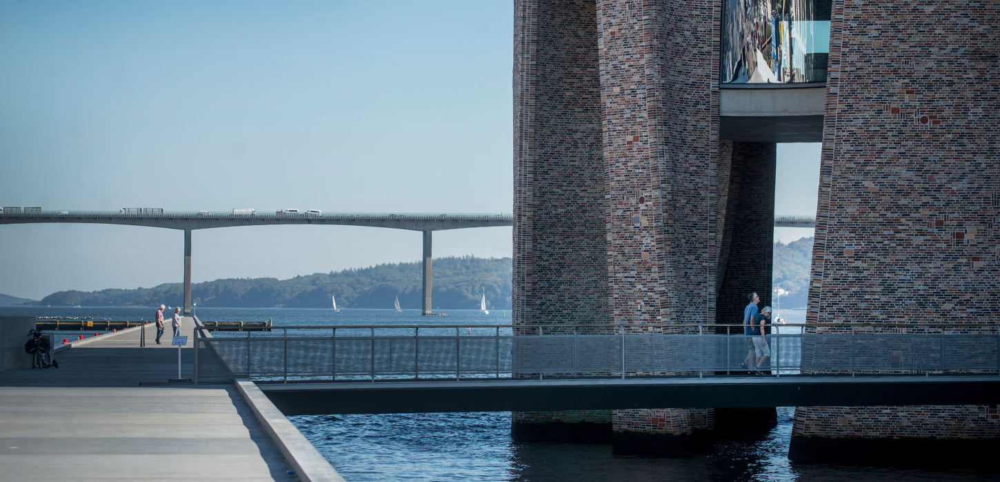 Gæster på vej ind i Fjordenhus på en sommerdag