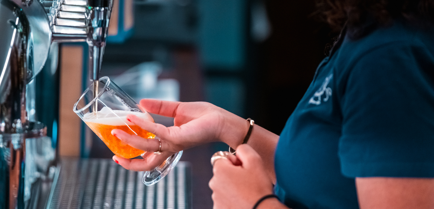 A bartender pouring beer at Paladspassagen Social Dining
