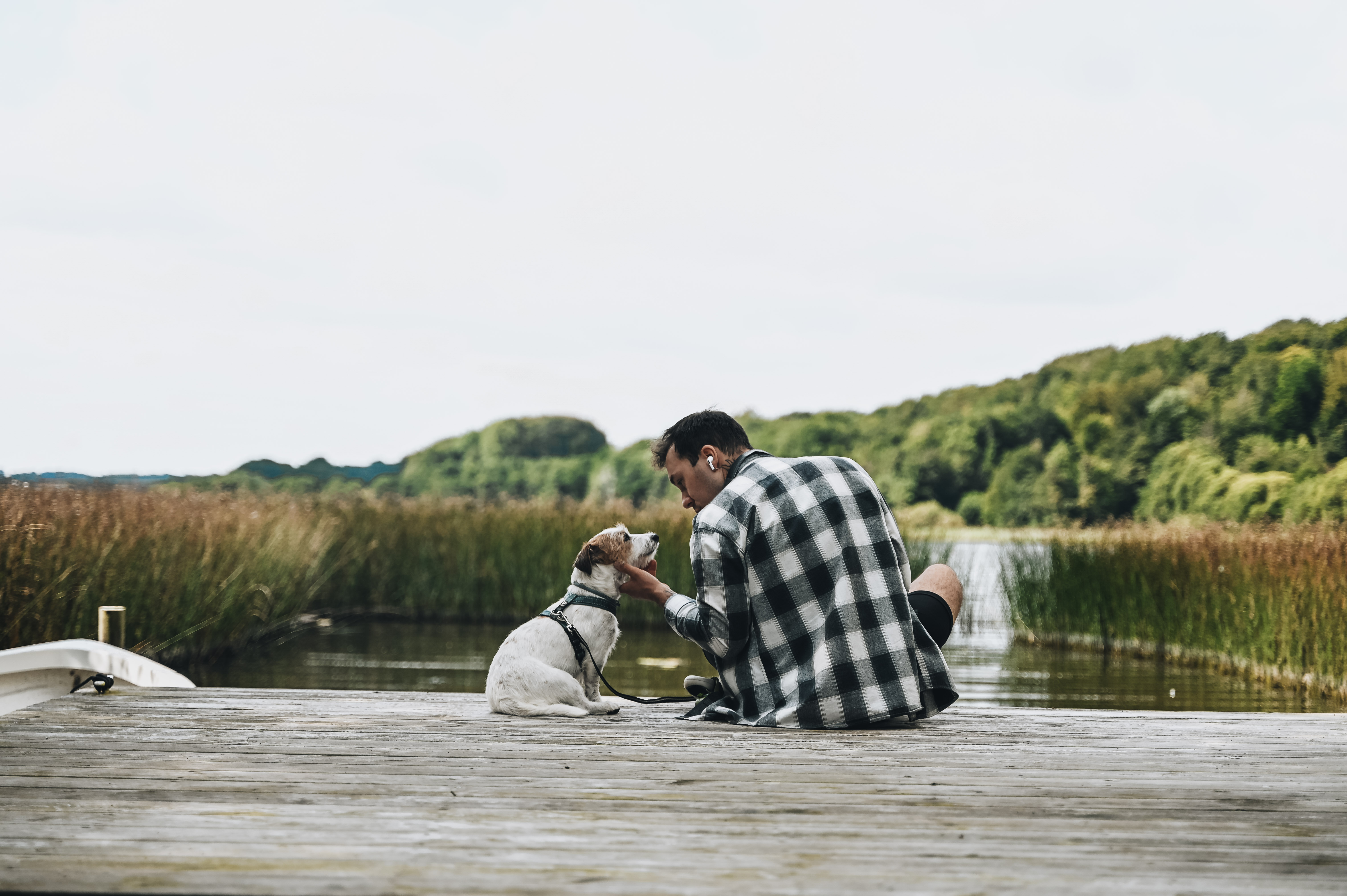 Ein Mann sitzt mit seinem Hund am Fårup Sø