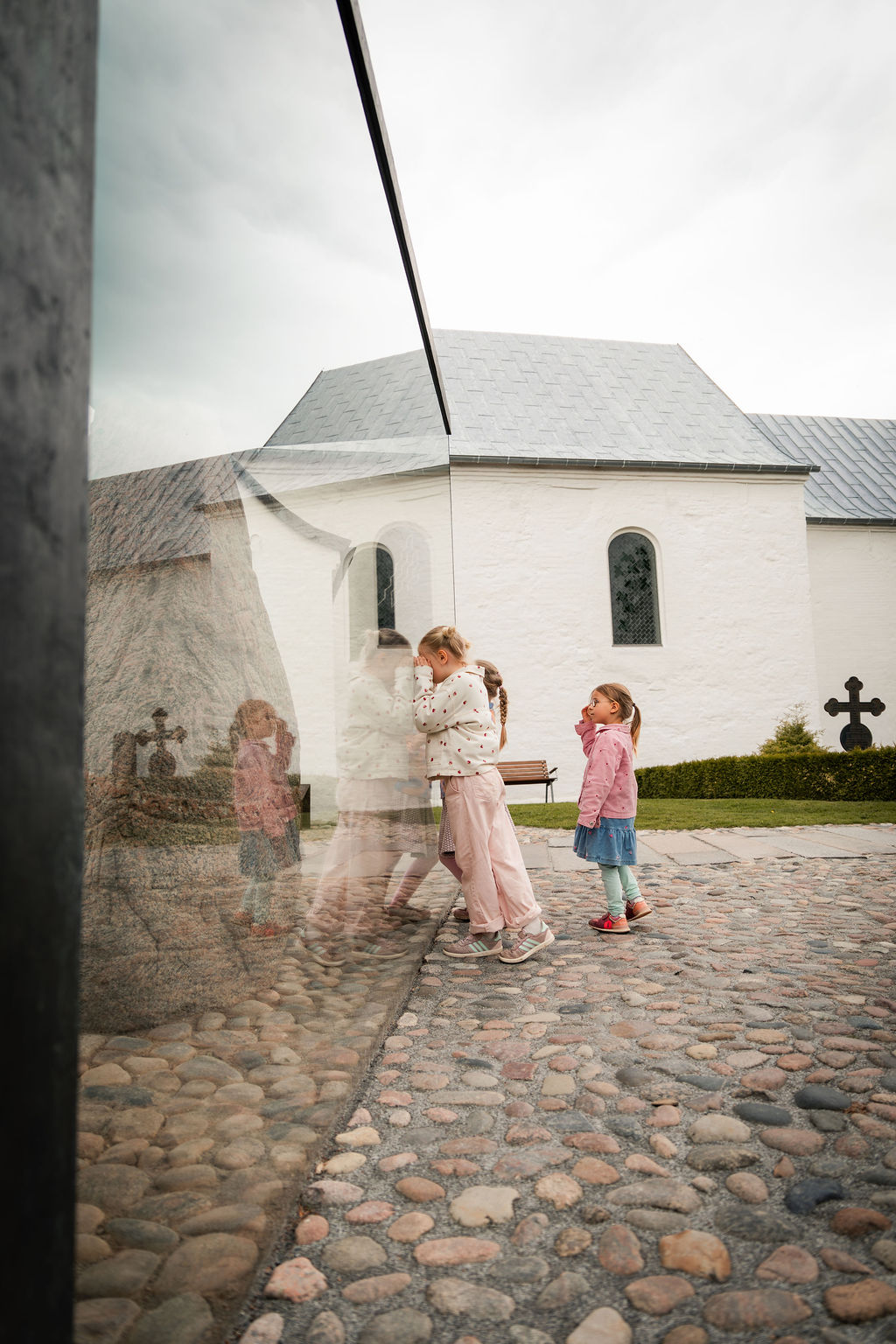 Zwei Mädchen spielen an den Jelling-Monumenten bei der Jelling-Kirche