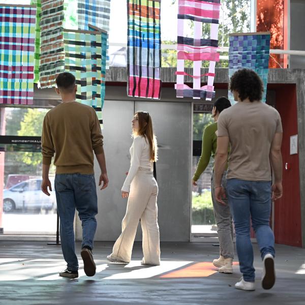 Four people walk around the Spinderihallerne in Vejle