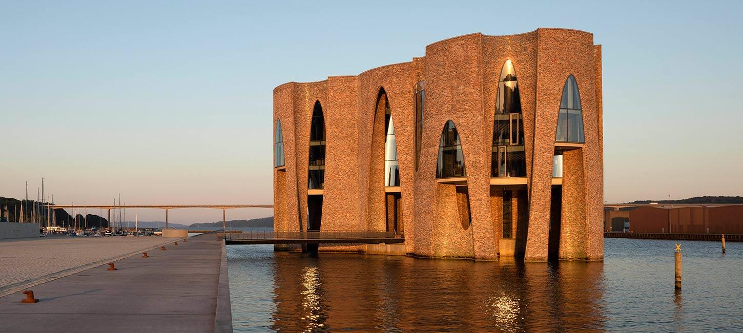 Fjordenhus med sol på ved solnedgang