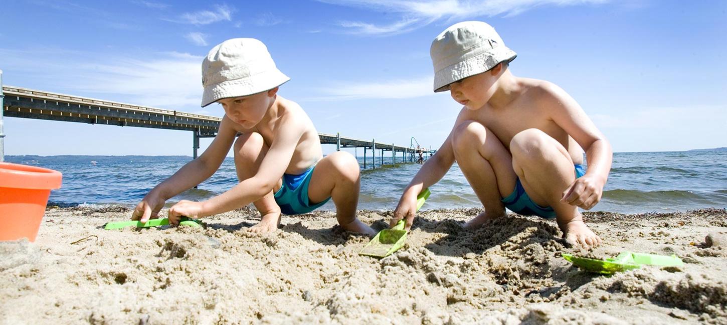 Children play in the sand at Hvidbjerg Strand on a summer day
