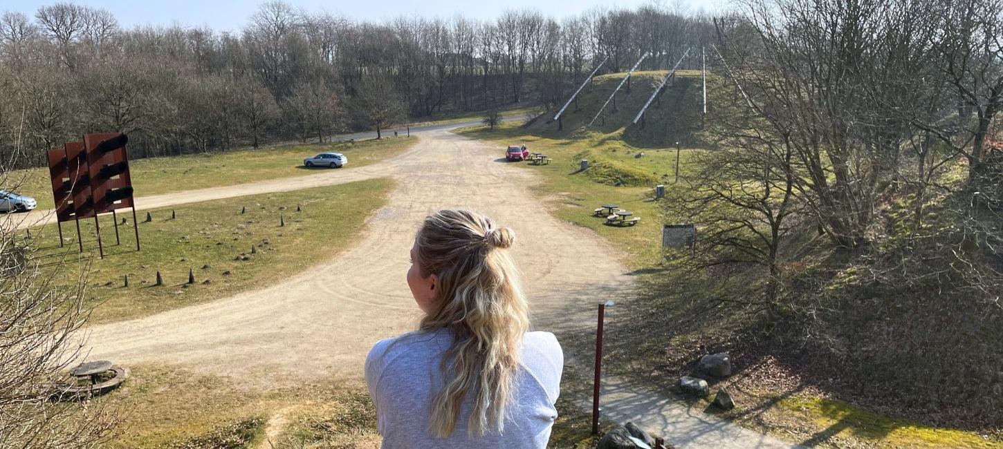 Person takes a break at Tørskind Gravel and enjoys the view of the gravel pit and the sculpture