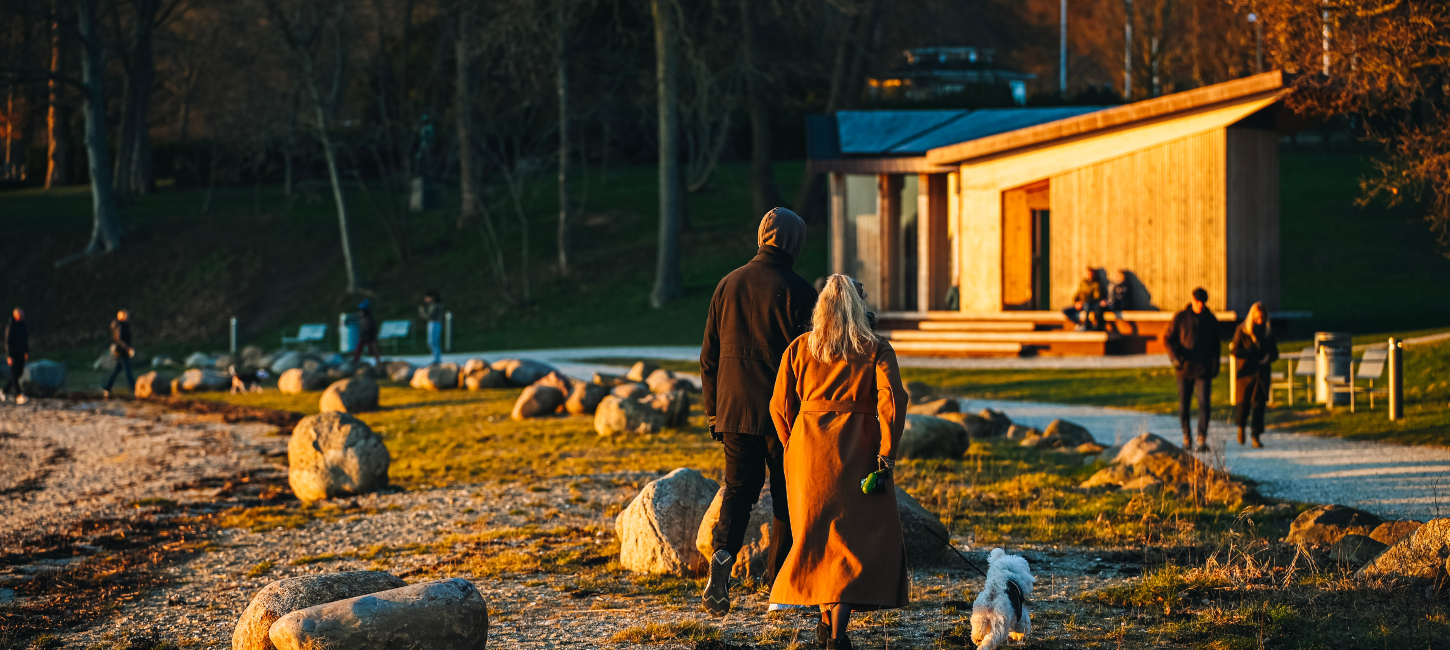Couple taking a walk in Skyttehushaven by Vejle Fjord on a spring day