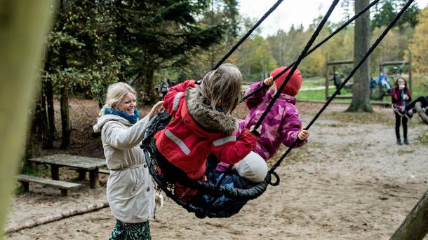 Children on swings at the forest playground in Sønderskoven in Vejle