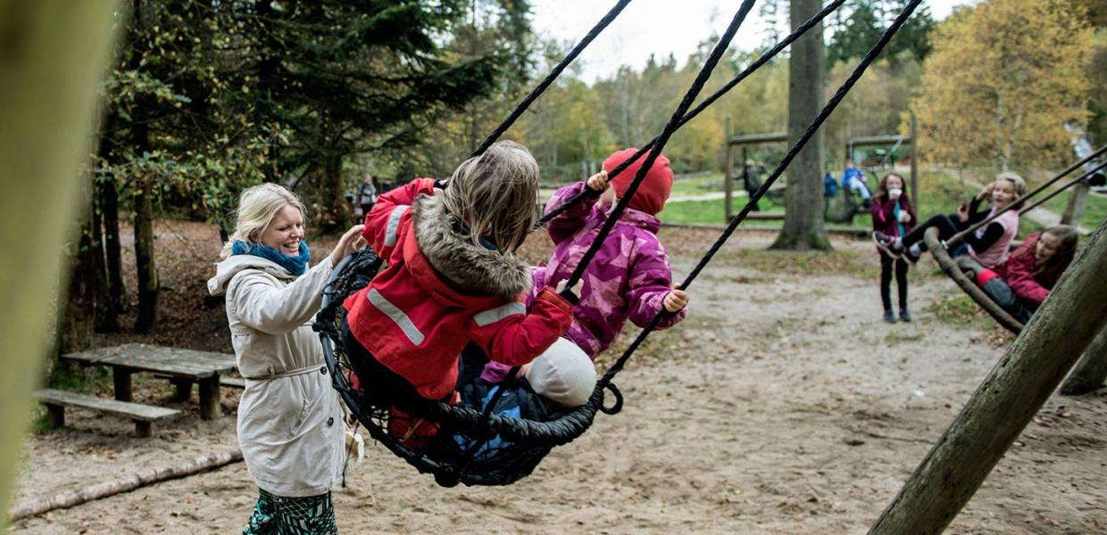 Children on swings at the forest playground in Sønderskoven in Vejle