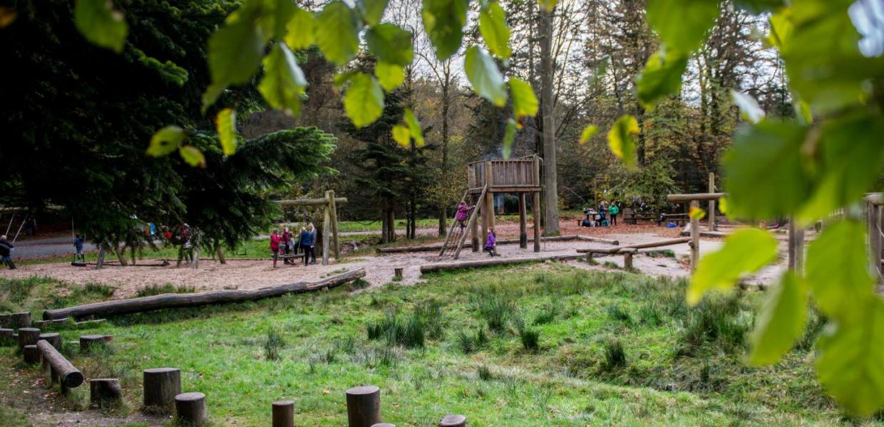 Family plays on the nature playground in Sønderskoven