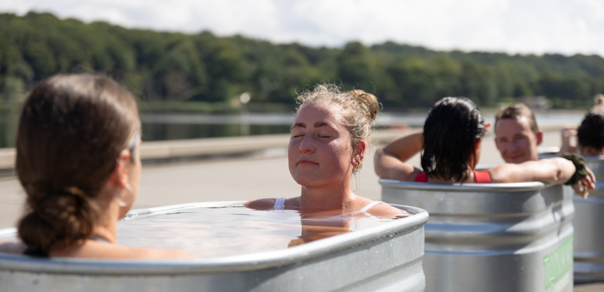 Women are sitting in a hot tub after saunagus with the Saunatruck in Vejle by the harbour