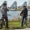 Three cyclists cycle along the East Coast Route and take a break at Vejle Fjord and enjoy the view of Bølgen