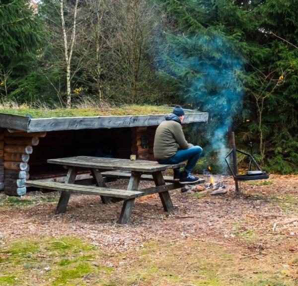 A person is on a shelter trip in Frederikshåb Plantation and makes a bonfire