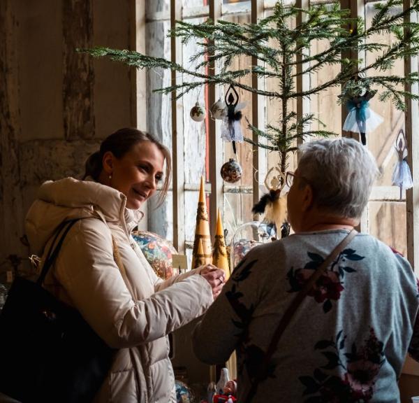 Two people look at stalls at the Christmas market at Tirsbæk Manor