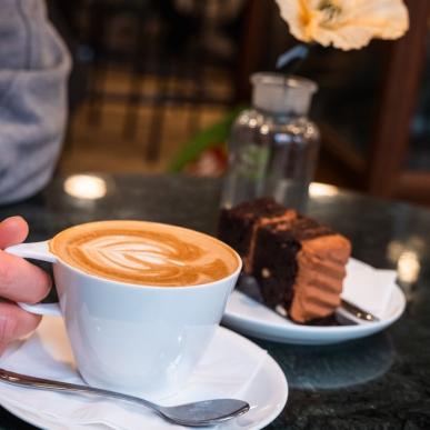 A person sits at the café Conrads and gets coffee and cake