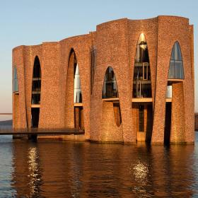 Fjordenhus with sun on it at sunset