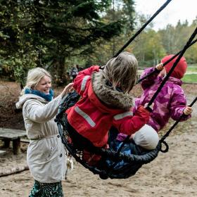 Children on swings at the forest playground in Sønderskoven in Vejle
