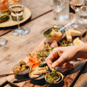 A couple enjoys tapas and a glass of wine on a romantic date in Torvehallerne