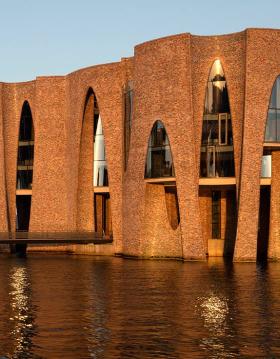 Fjordenhus med sol på ved solnedgang